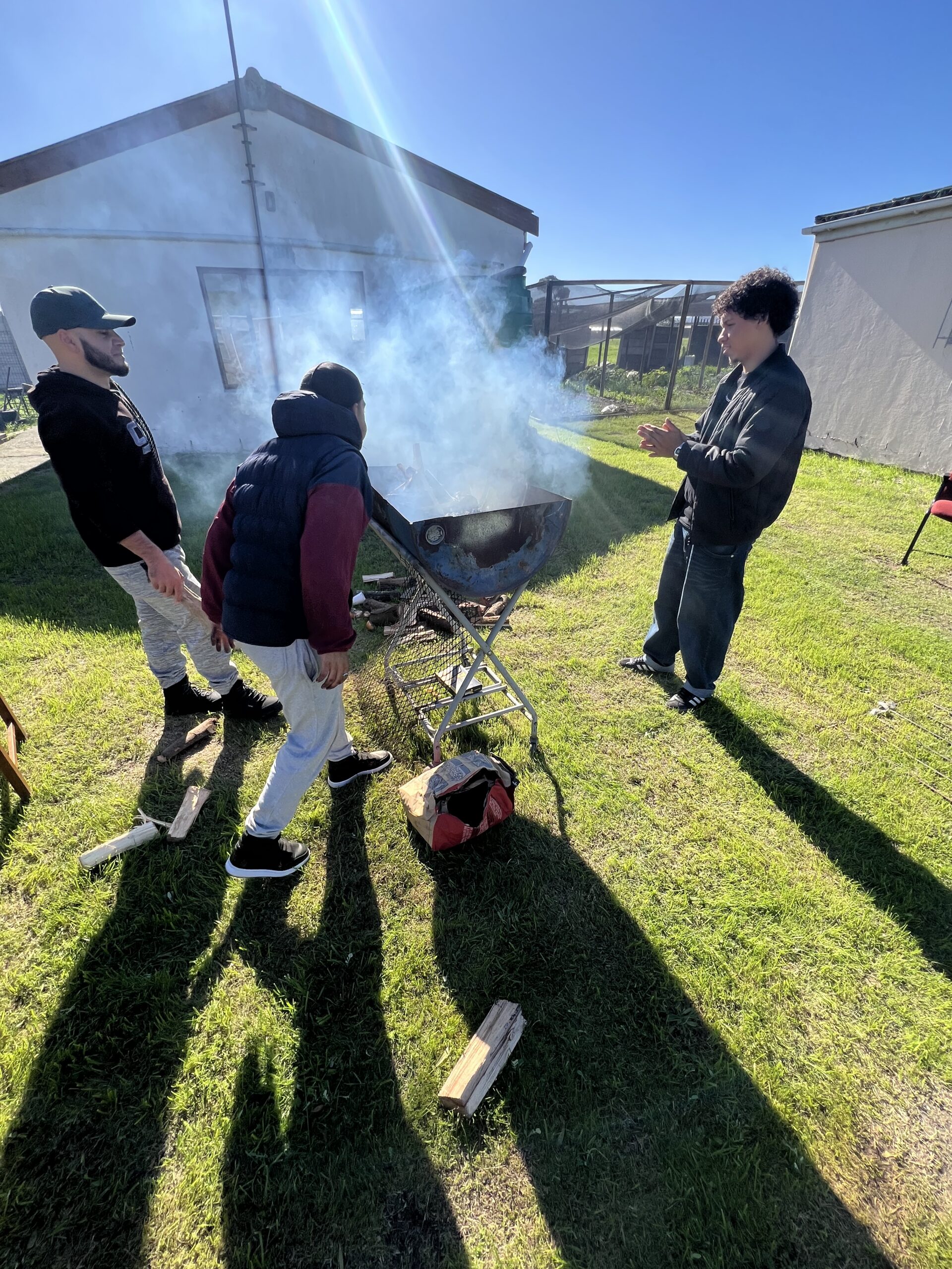 Volunteers braaiing meat over an open fire at the Tshisanyama